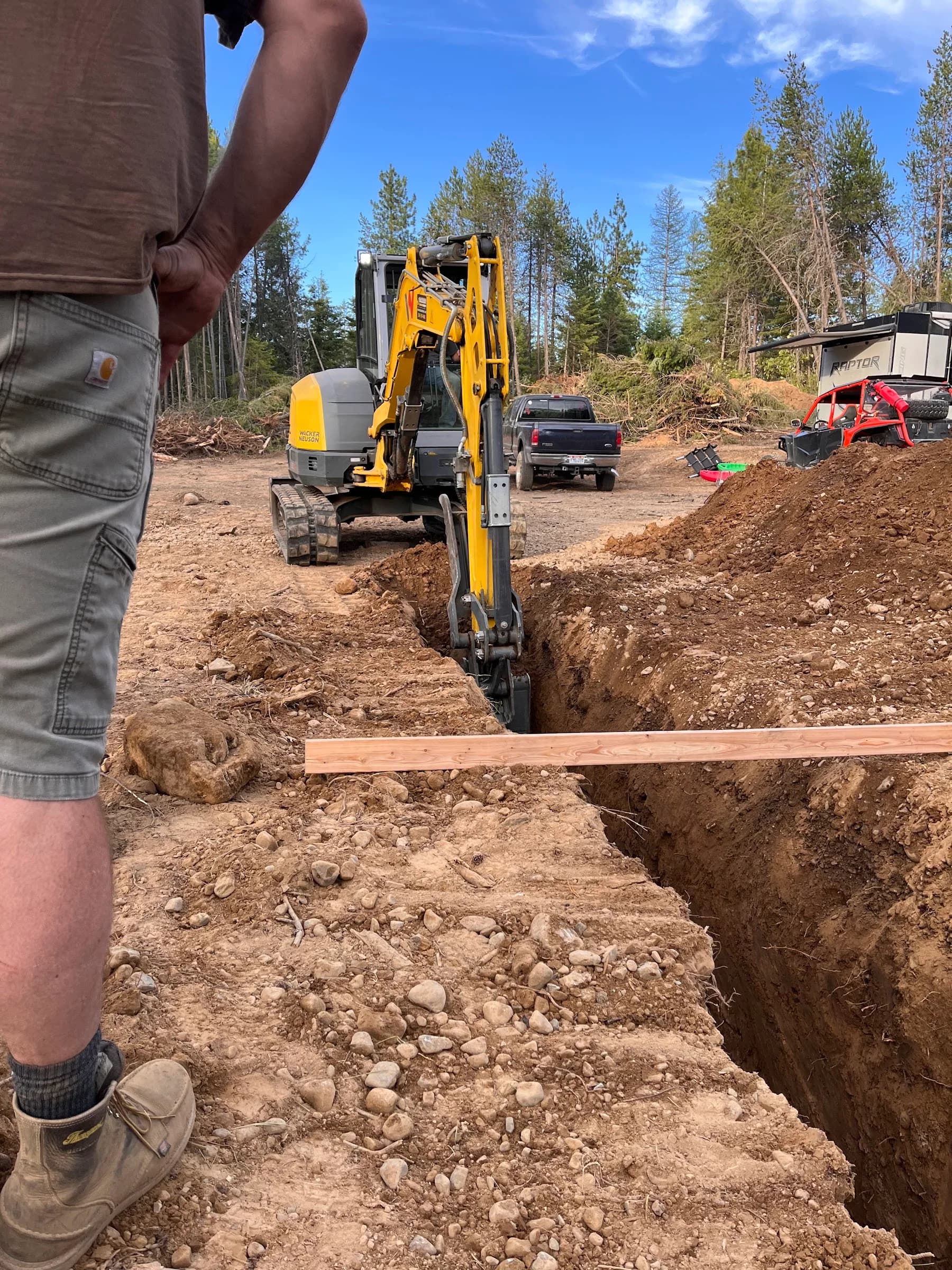 Excavator bucket at work in an open trench