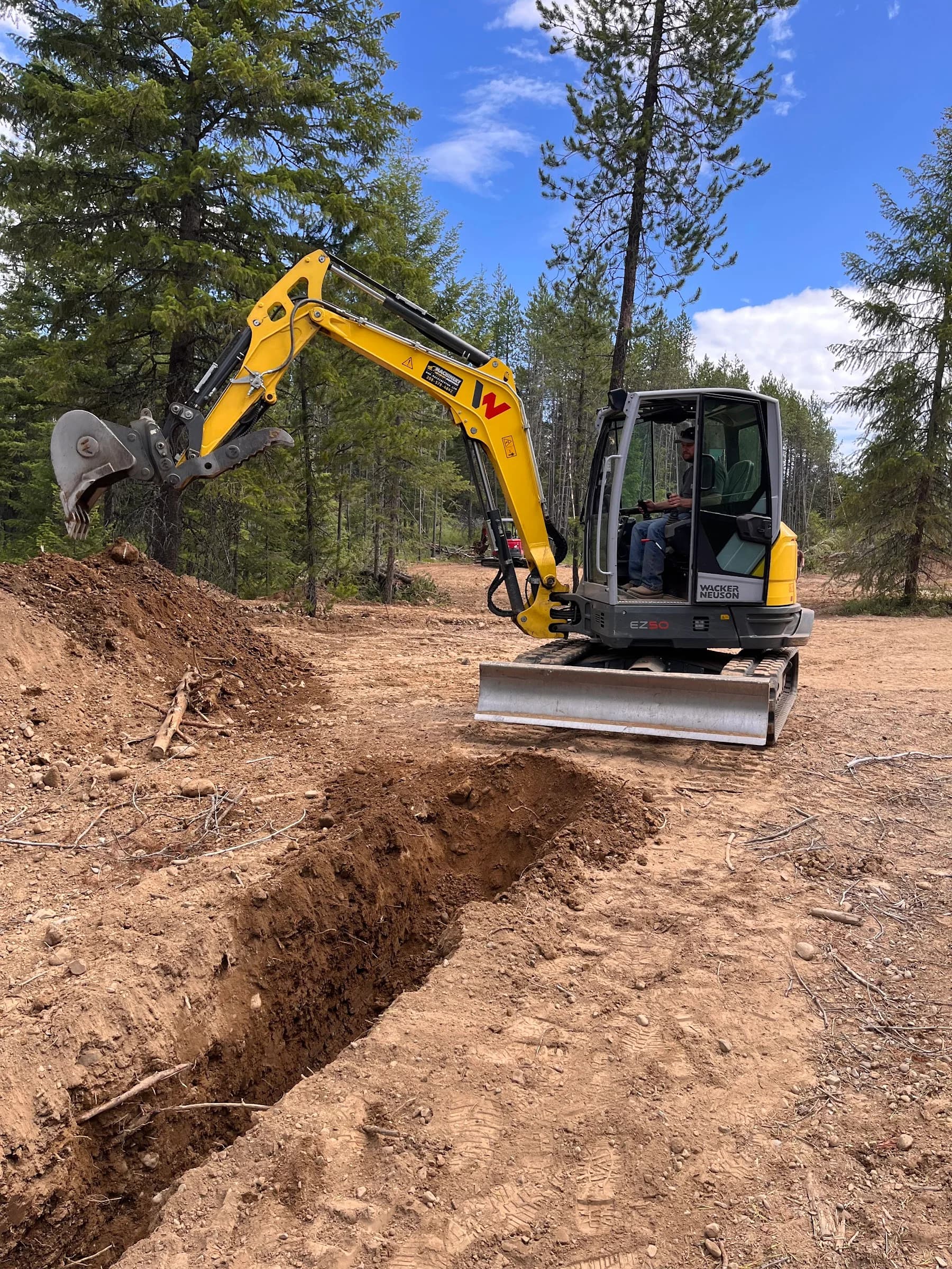 Excavator beside a trench at a Taylor Creek work site